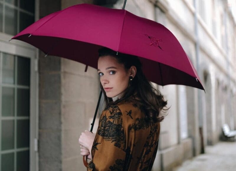 Portrait femme portant un parapluie de Cherbourg rose